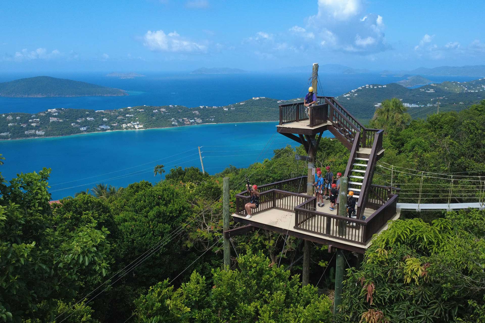 Guest taking off on the famous 'Yo-Yo' zipline with Caribbean islands and turquoise water views.